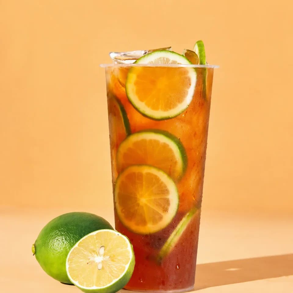 Enhanced lemon black tea with citrus fruit in a bright orange setting